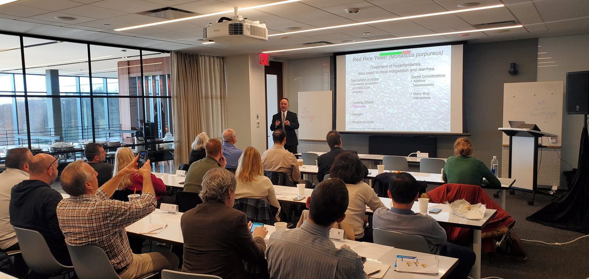 Speaker presenting to seated guests at a corporate training seminar